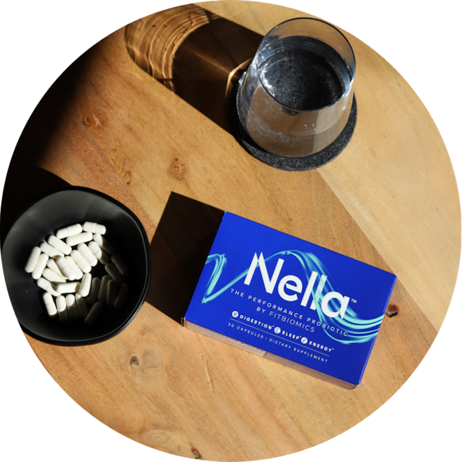 nella next to a bowl of capsules and a glass of water