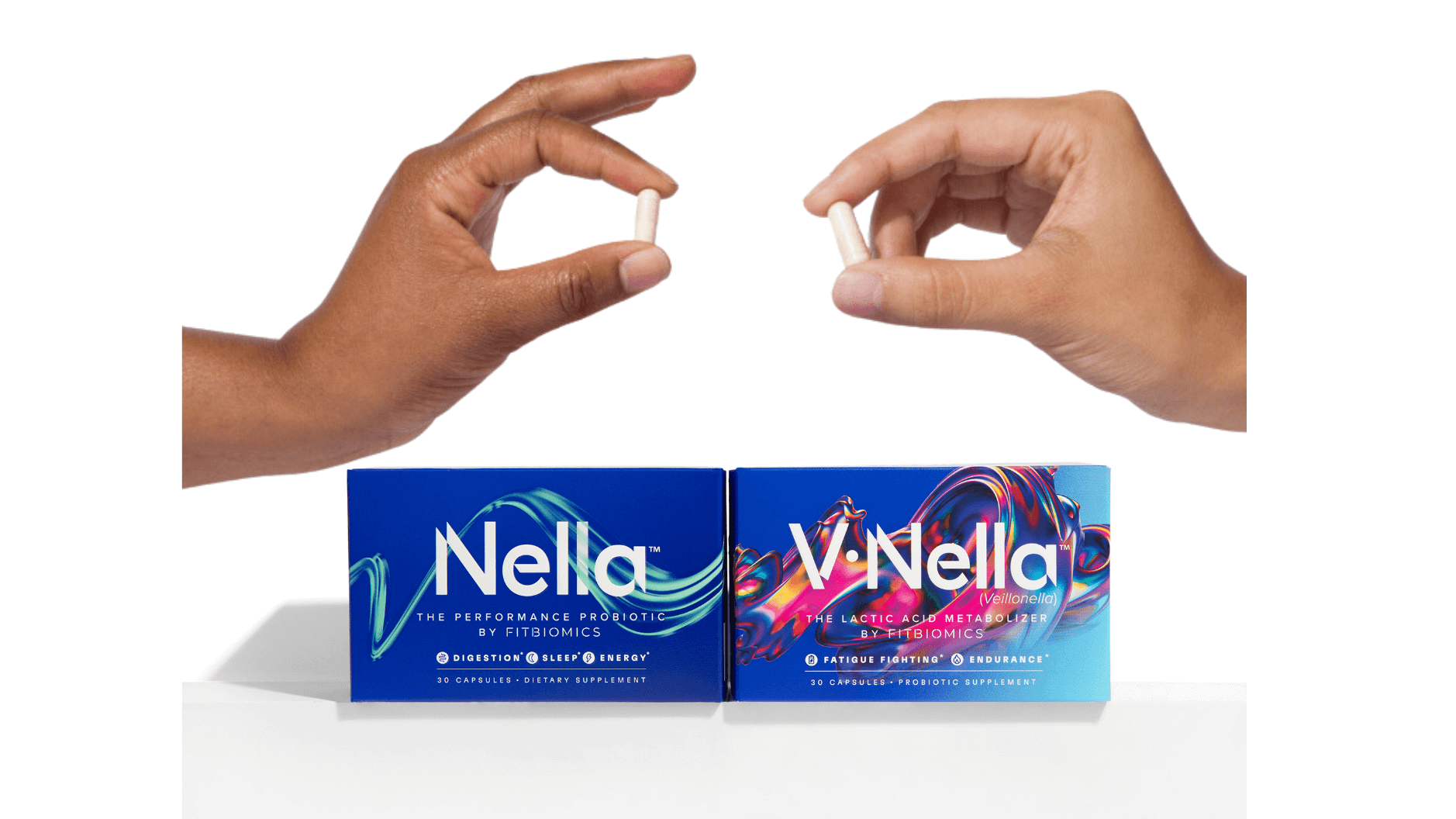 2 hands holding fitbiomics capsules above boxes of Nella and V•Nella