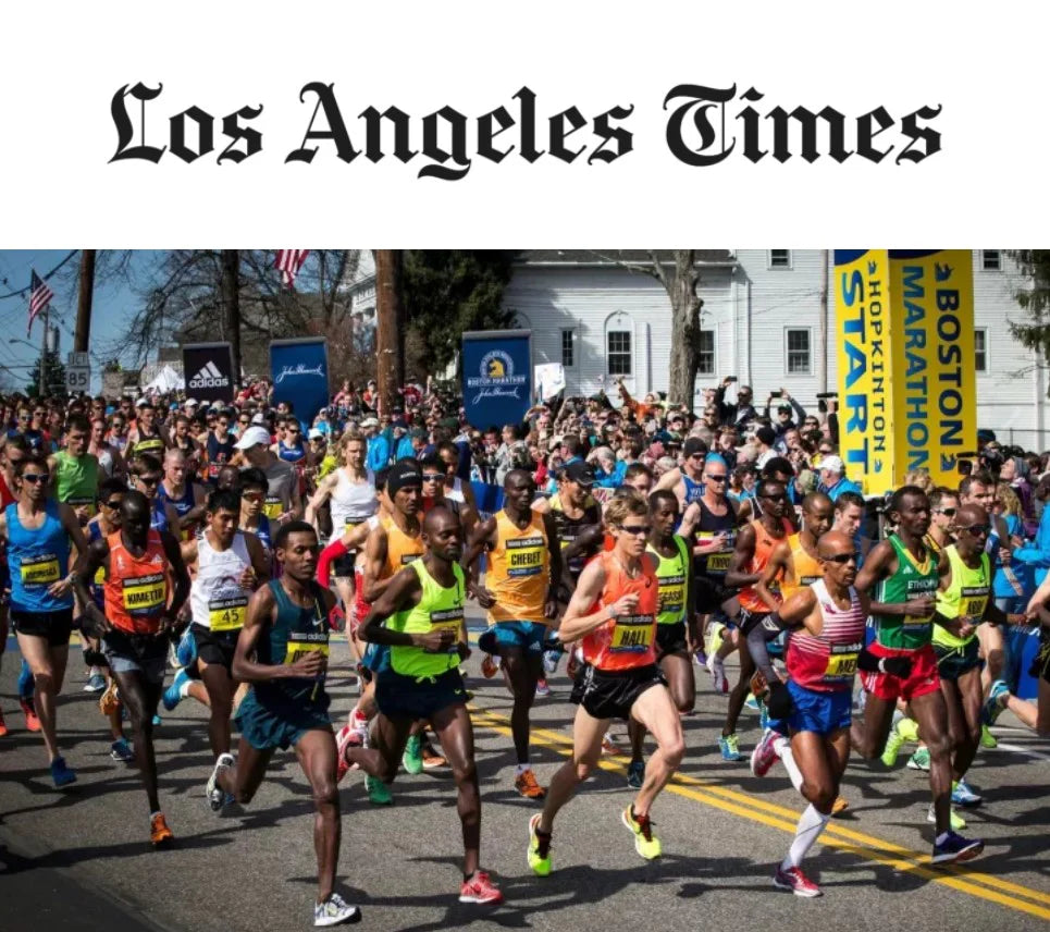 Action photo of marathon runners in a group under LA Times logo